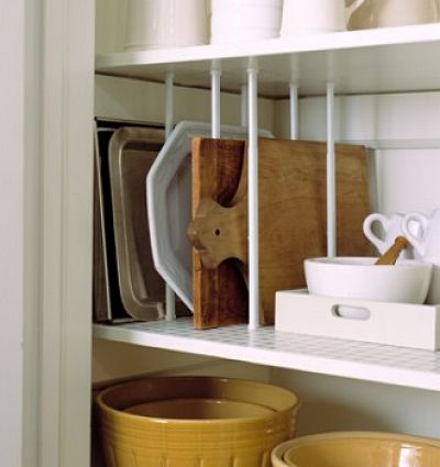 Use tension rods to organize cutting boards and other flat items