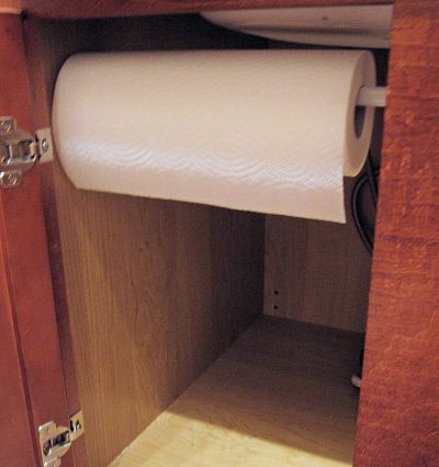 Use a tension rod to hold a roll of paper towels