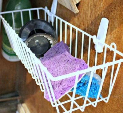 Use hooks to hold a basket under the sink to hold sponges